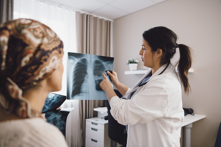 Photo shows a doctor discussing results of an X-ray with her patient/Getty Images