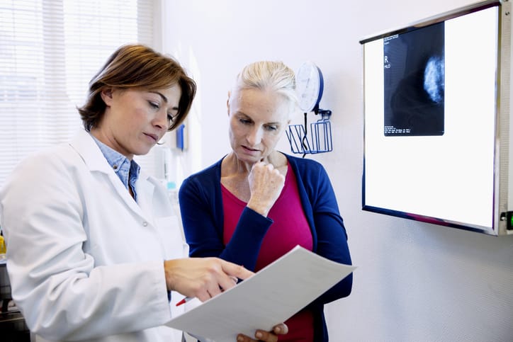 A doctor explains mammogram results to a patient/Getty Images