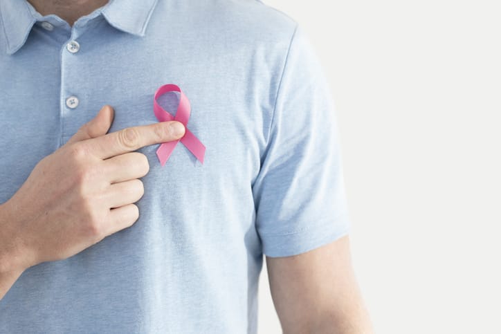 Photo shows a man wearing a breast cancer awareness ribbon/Getty Images