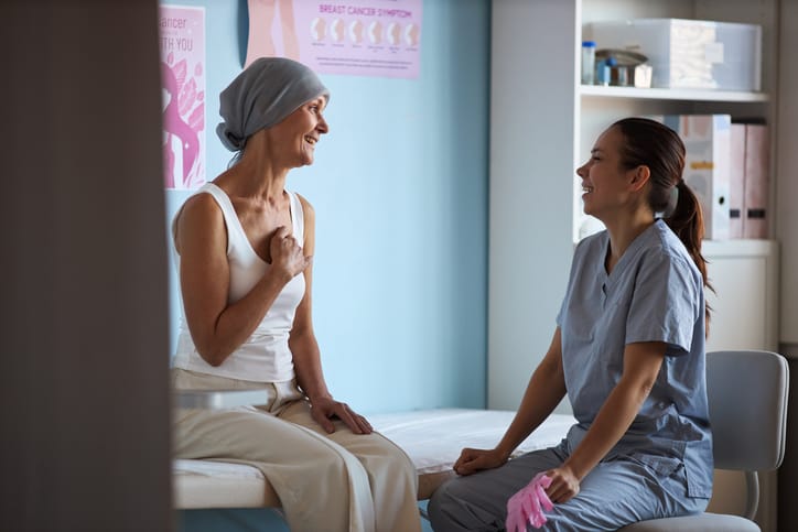 Photo shows a middle-aged woman with breast cancer talking to her doctor/Getty Images