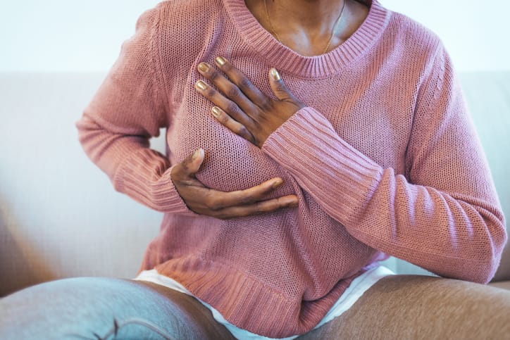 Photo shows a young woman feeling her breast for cancer signs/Getty Images