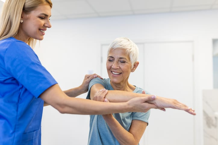 Photo shows a woman attending a physical therapy appointment/Getty Images